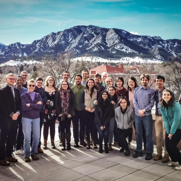 large group of people posing in front of mountain backdrop