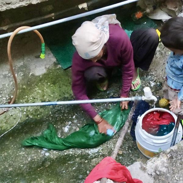 Woman washing material in water