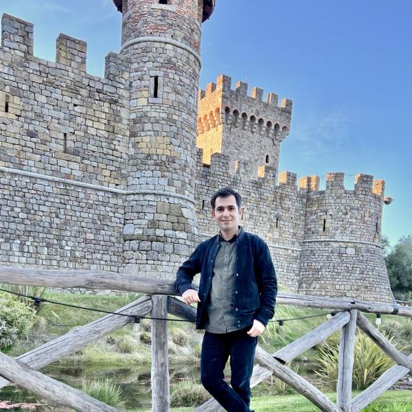 Behzad Vahedi standing in front of stone castle