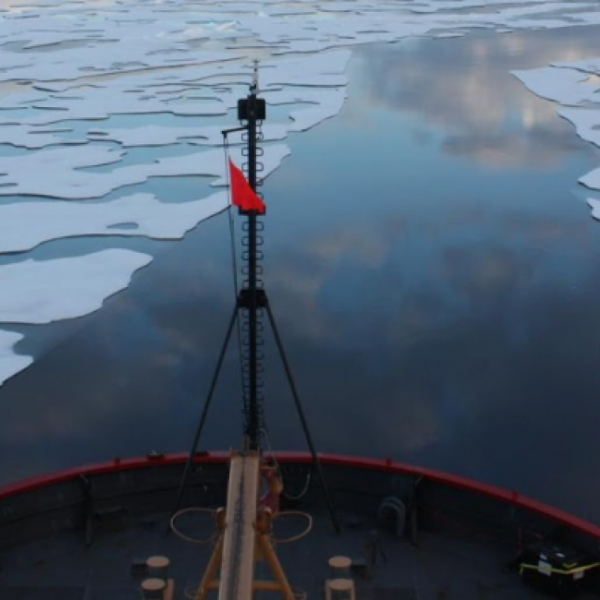 Bow of ship sailing over melting arctic ice