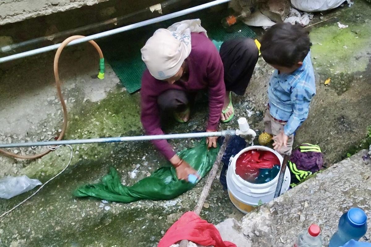 Woman washing material in water