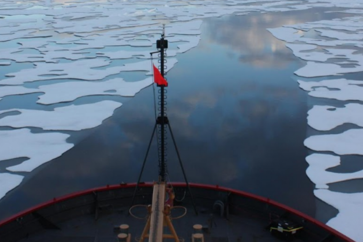Bow of ship sailing over melting arctic ice