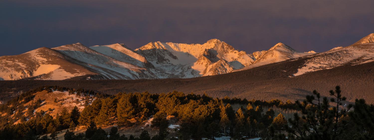 Mountain scene with gold sunlight on snow covered mountains