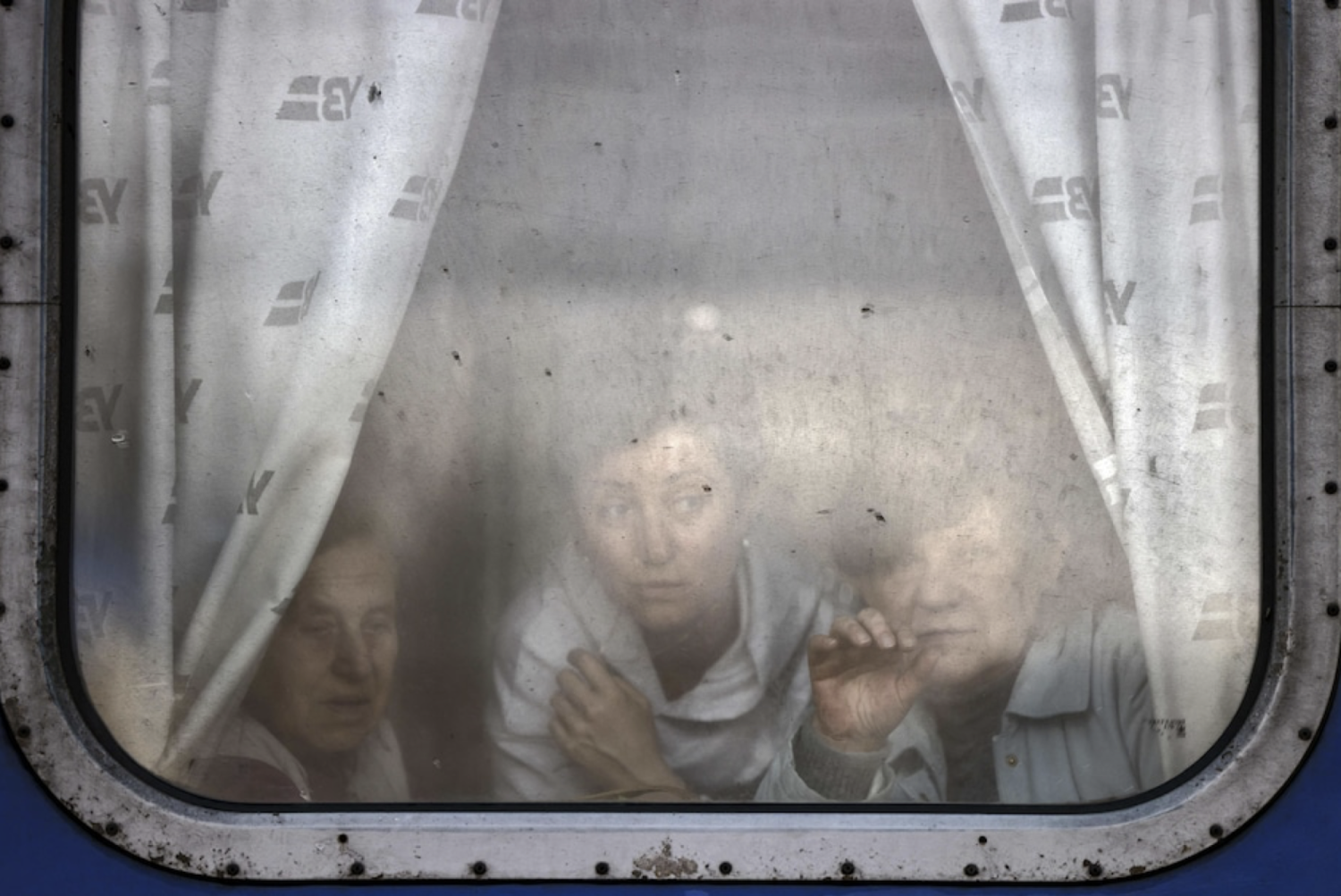 Women wave out window as they are about to leave by train