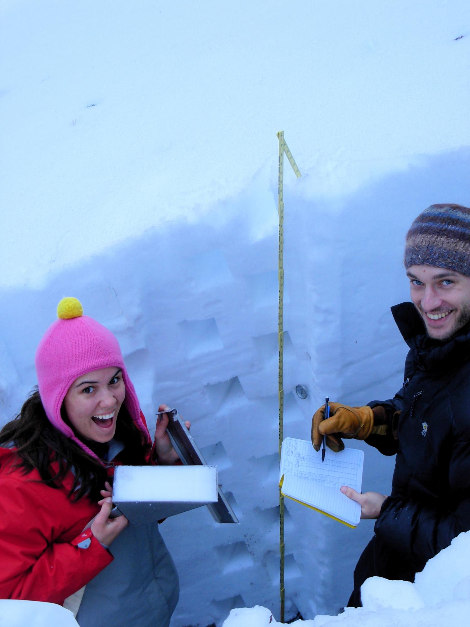 2 students checking snow depth in the mountains