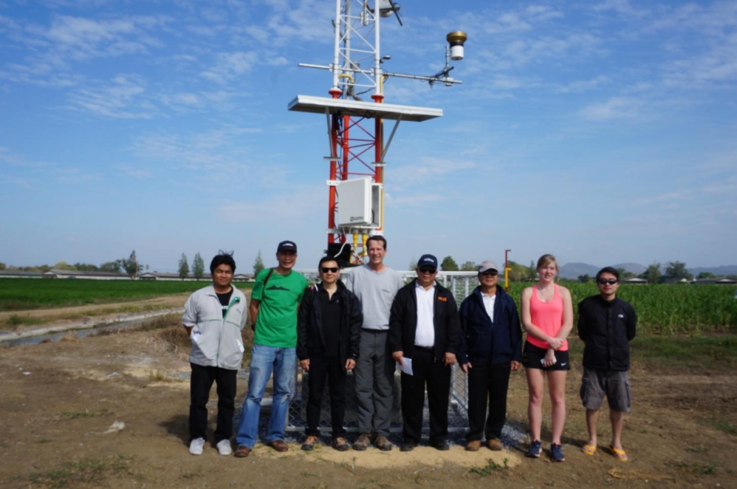 Group of 8 people standing in front of meteorological tower
