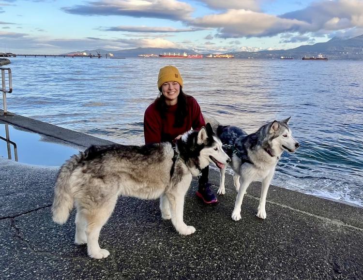 On waterfront with 2 husky dogs