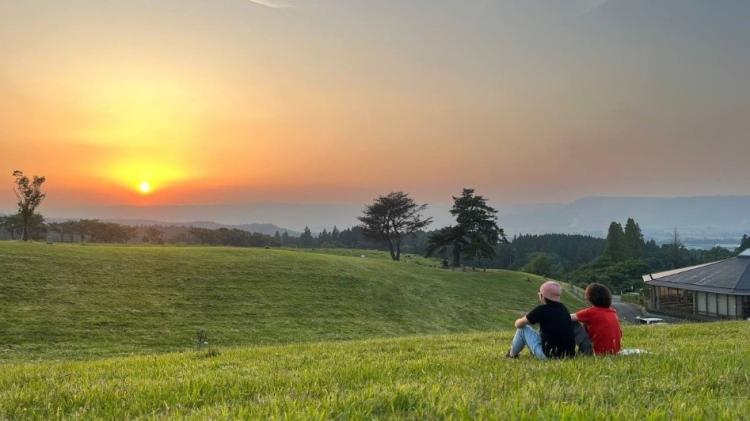 Chris observing the sunset in Aso, Japan with a student