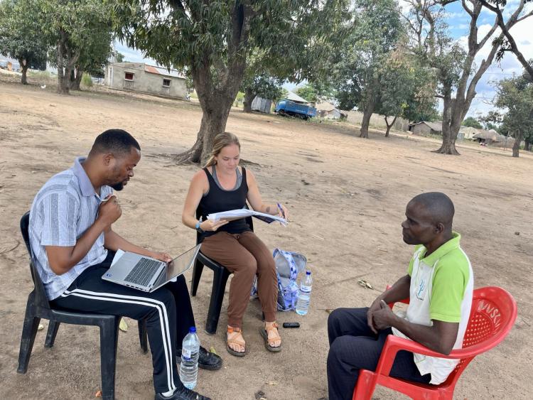 Eduardo Mondlane University master’s student and research assistant Aldimiro Carlos translates from the local language of Sena to Portuguese while Herwehe takes notes during an interview with a farmer in Metuchira, Sofala.