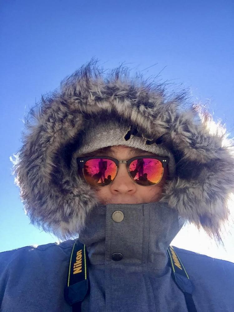 Headshot of man in parka wearing sunglasses