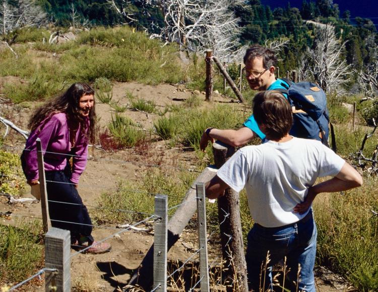 Man leaning against fence talking to 2 people in Argentina