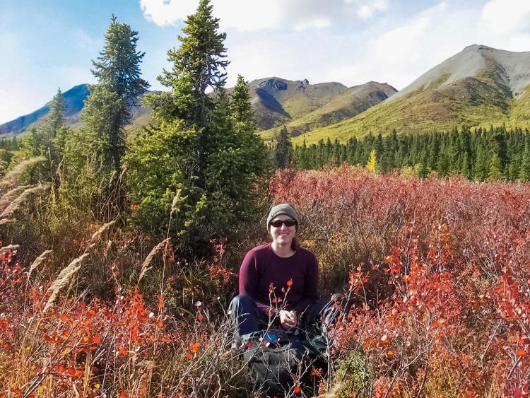 Woman among vegetation with mountain range in background