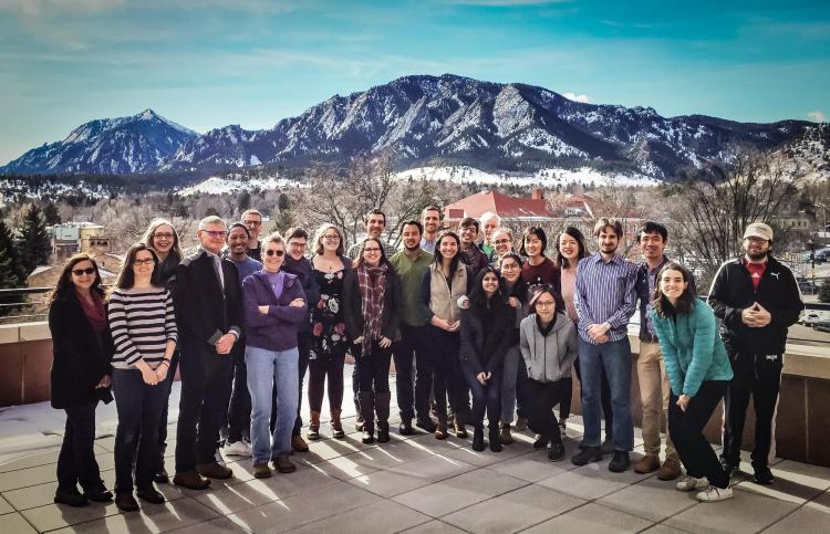 large group of people posing in front of mountain backdrop