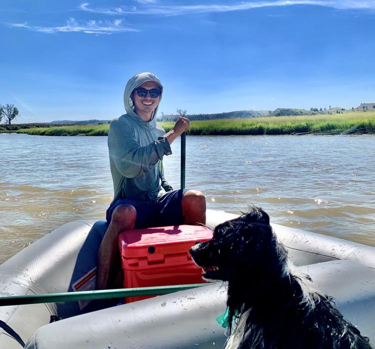 Man and dog in raft on river