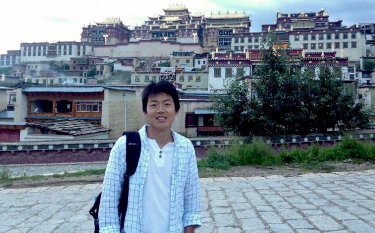 Student posing with Tibetan city in background