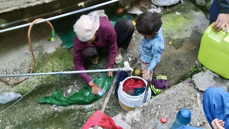 Woman washing material in water