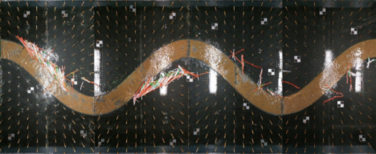 Figure 3: Image from above of the physical model after an experiment was conducted. Orange, white, and green pieces are scattered around the model. Flow is from left to right.