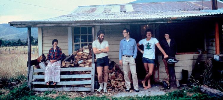 Group standing on front porch of old house in New Zealand