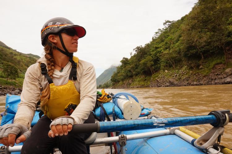 Woman rows a raft on a river