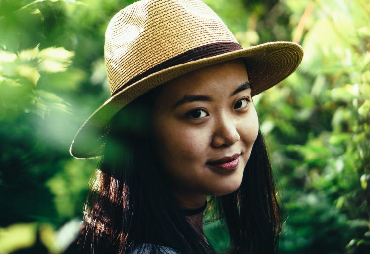 Young woman smiling and wearing straw fedora