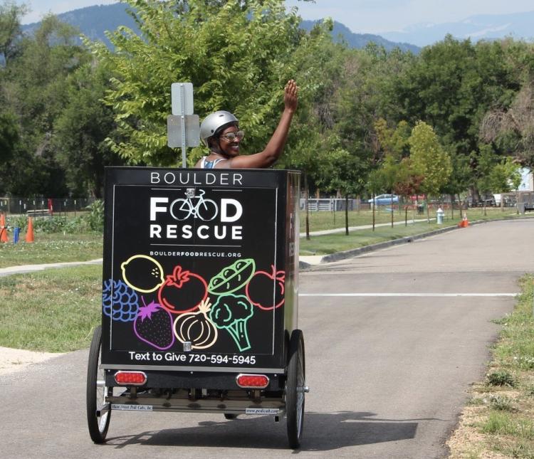 man pedaling a Boulder Food Rescure cart