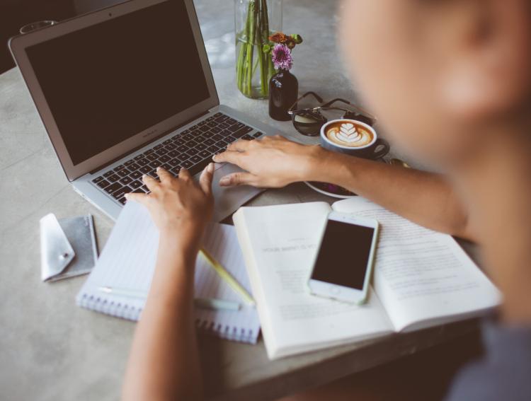 Student at table typing on a laptop