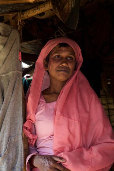 Refugee woman standing and wearing pink garb