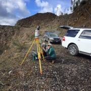  people on mountain with survey equipment