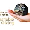 A hand holding the GEOG logo with the words "Our future is in your hands" and "Charitable Giving"