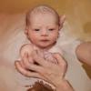 baby in water held by adult hands