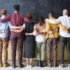 People embracing in front of a chalkboard 