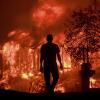 Silhouette of man walking toward wildfire