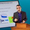 Man talking at lectern in front of screen