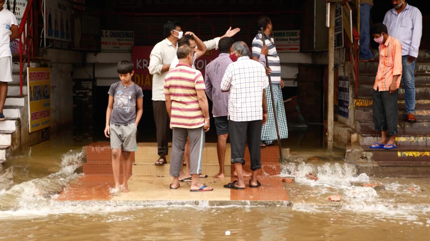 People standing above floodwaters