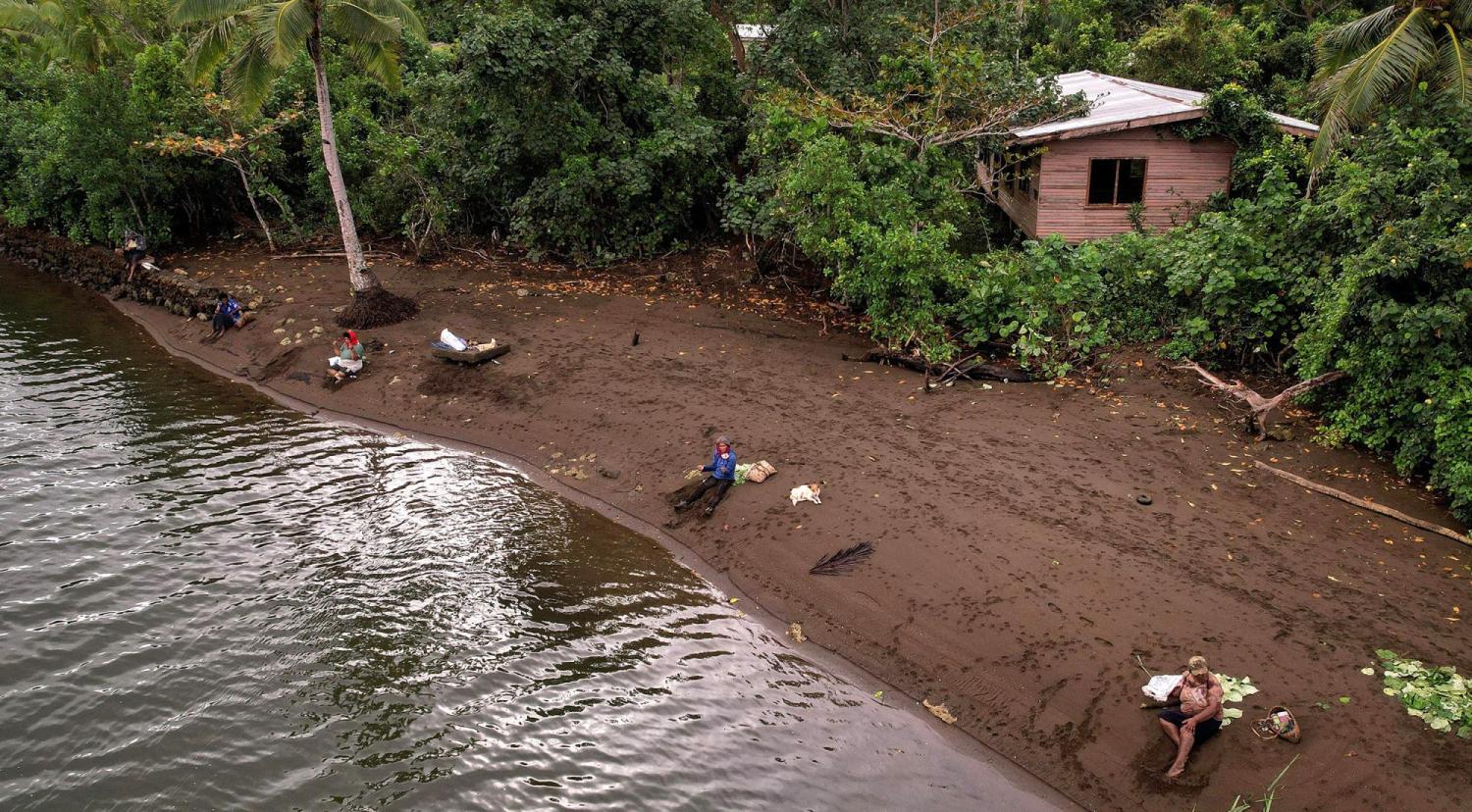 Local residents fish in front of the abandoned site of the old Vunidogoloa Village, Fiji