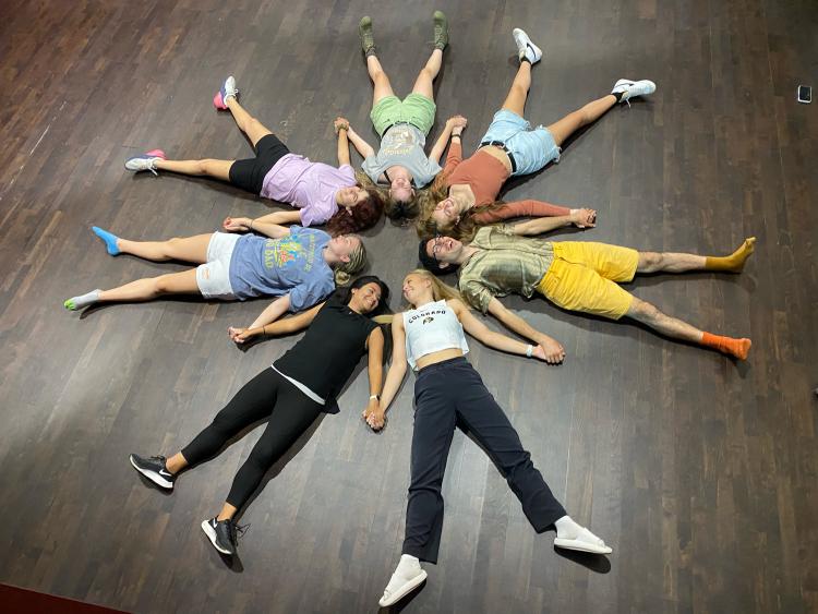 Students laying down to form in a circle