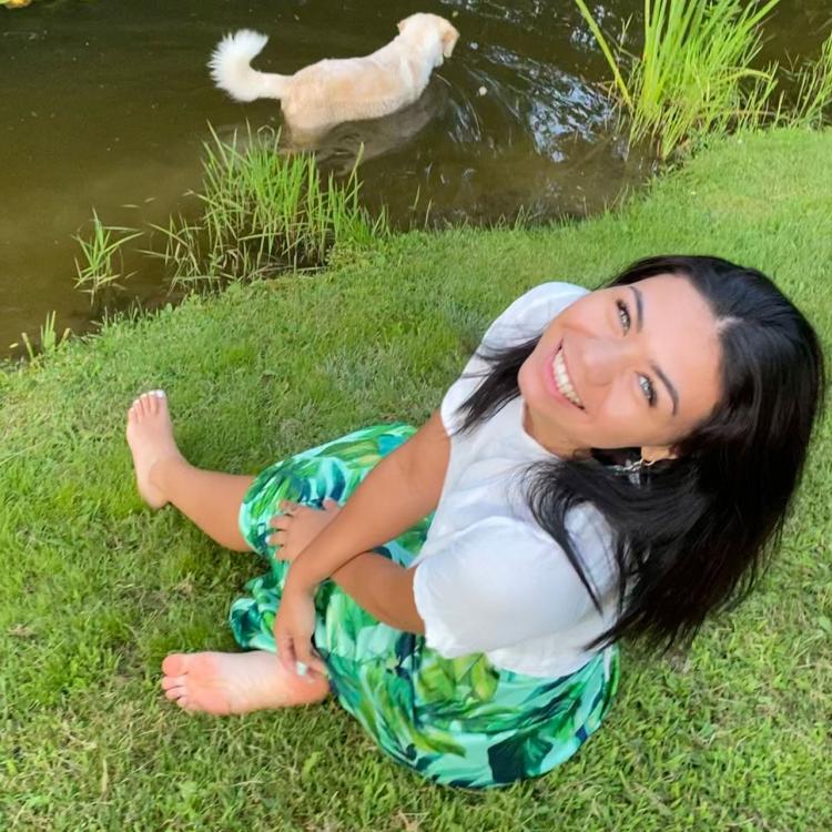 Tia Kennedy with her dog wading in pond
