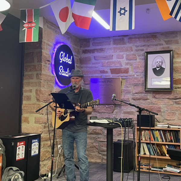Carl Hager, the host of open mic night, singing and playing the guitar