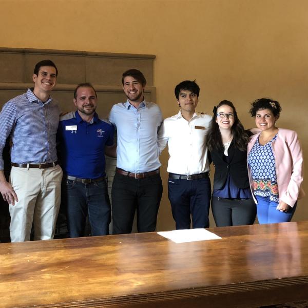 All of the founders of the Graduate student government presidents with signed copy of Grad students discuss the founding of the Colorado Federation for Graduate Students constitution stand with signed copy