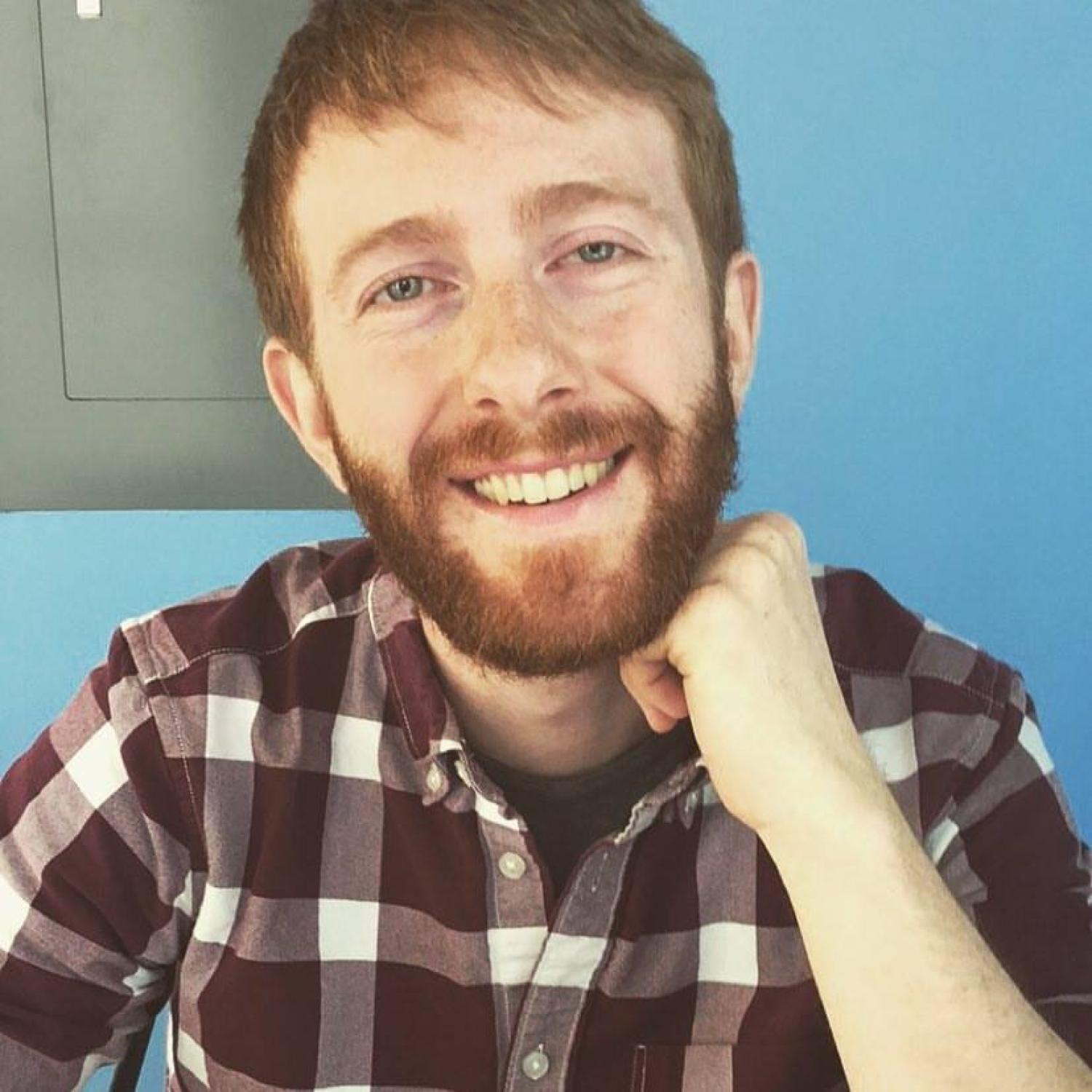 picture of Matt in a plaid shirt in front of a blue background