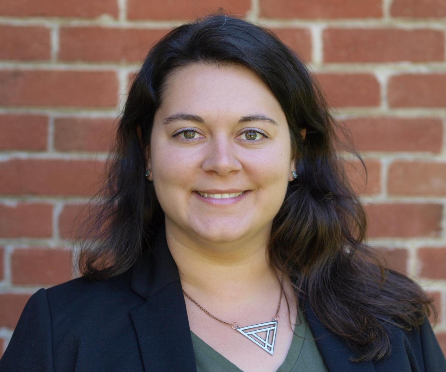 Headshot of Jone in front of a brick background