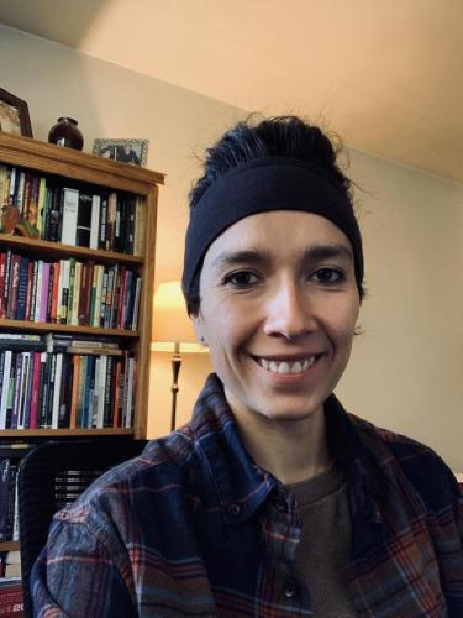 headshot of Laura in front of a book shelf