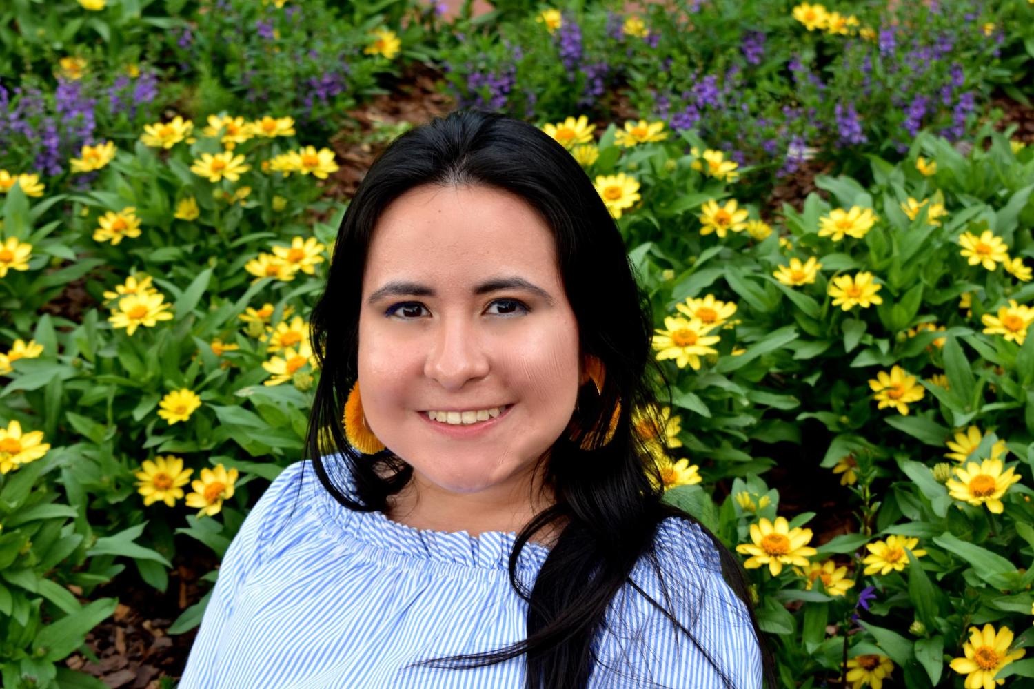 Headshot of Pamela with flowers in the background