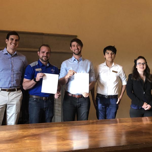 Graduate student government presidents with signed copy of Grad students discuss the founding of the Colorado Federation for Graduate Students constitution