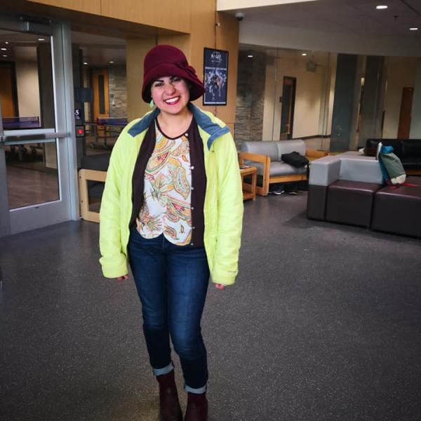 Grad student stands smiling post-ice-skating