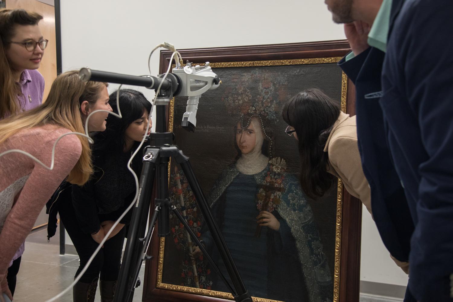 Art students examining a painting