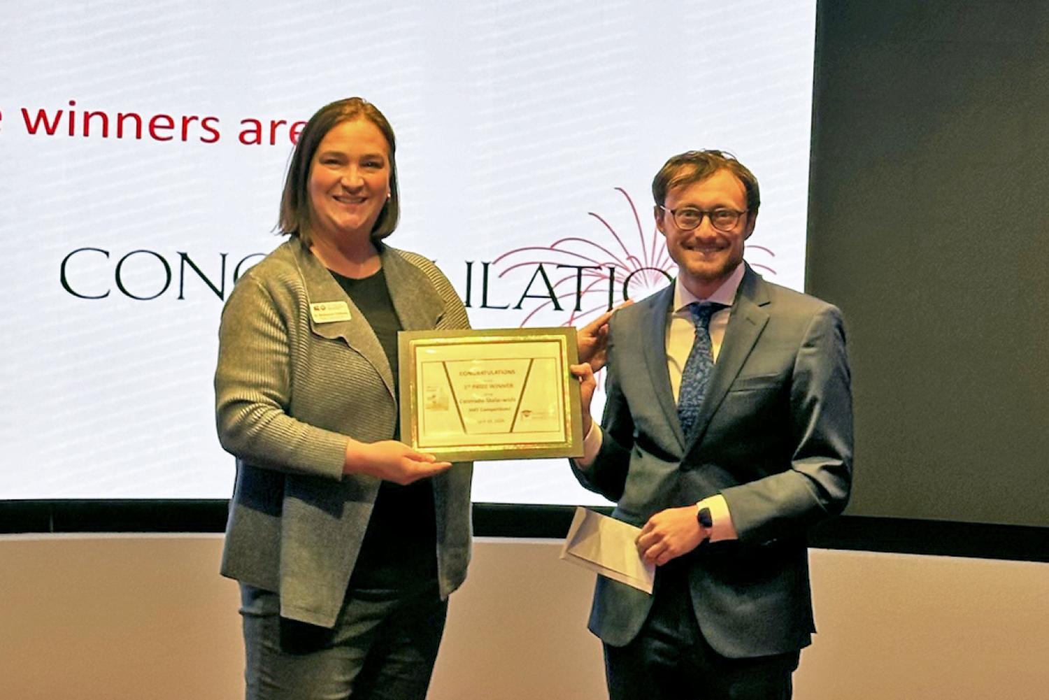 Zach Schiffman accepting the award after winning the 2024 Colorado 3MT final competition