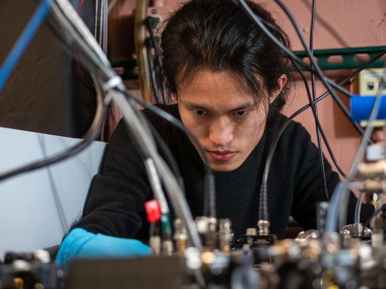 Qizhong Liang, a PhD candidate in JILA and the Department of Physics, poses in the lab.