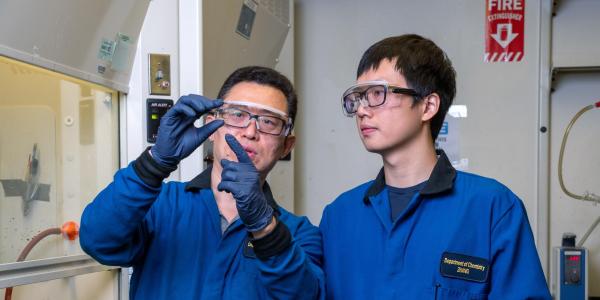 Chemist Wei Zhang with a student in his lab