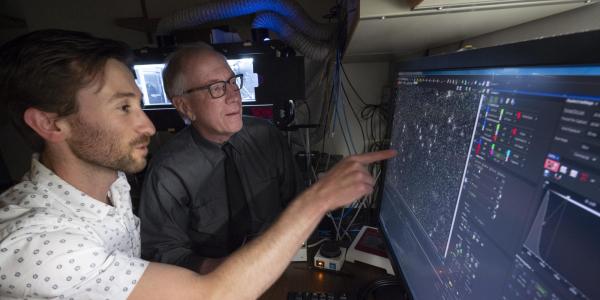 A student shows data to Nobel Laureate Tom Cech